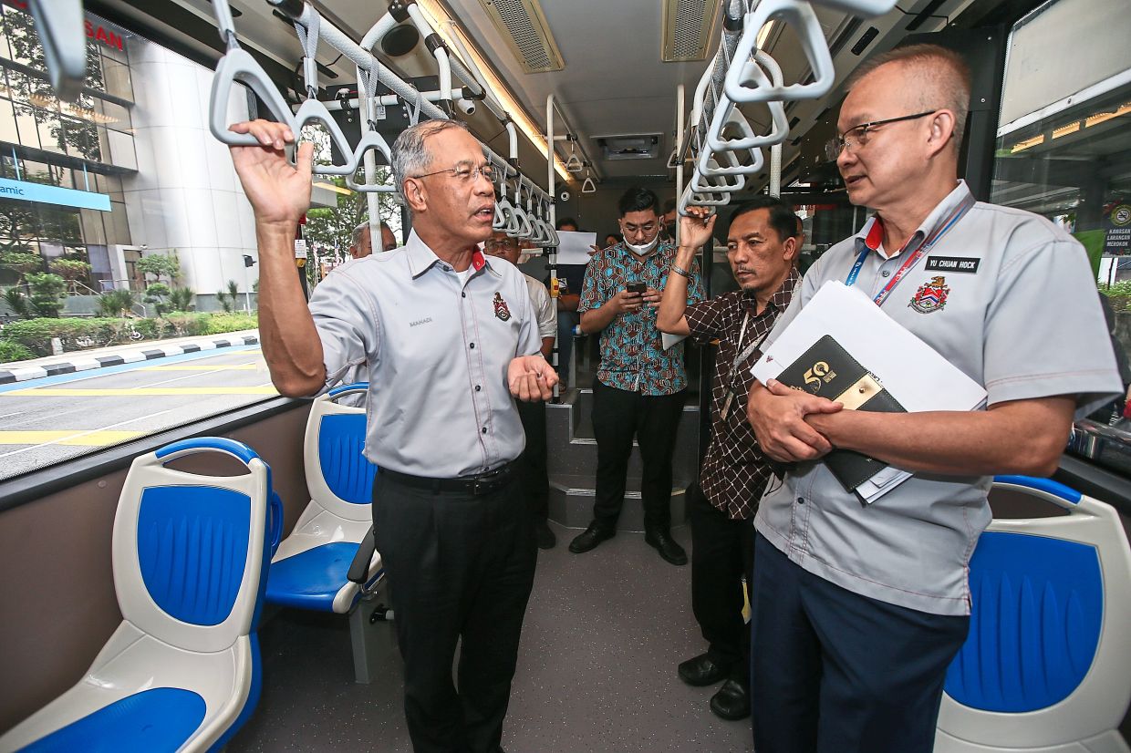 Mahadi (left) with DBKL Road Transport Department director Yu Chuan Hock (right) during a trial run along the new GoKL Cream Line and Magenta Line bus routes.