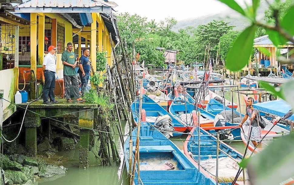 Muhammad Bakhtiar (left) visiting a fishing village in his constituency in Balik Pulau. — Courtesy photo