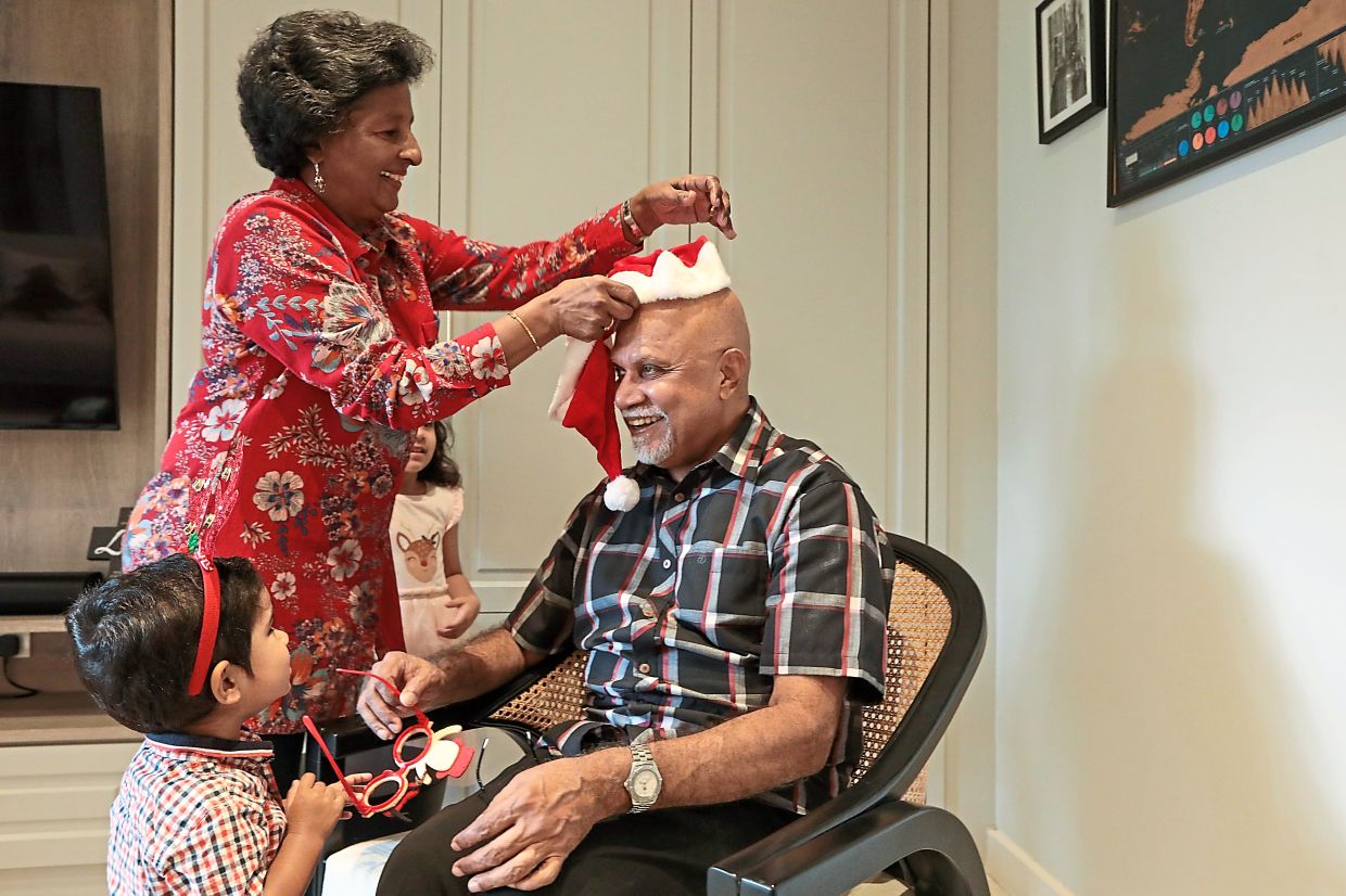 Dr Reena playfully puts on a Christmas hat on her husband Dr Samuel as little Christopher looks on.