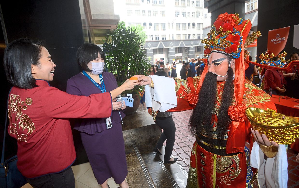 SMG staff receiving mandarin oranges from the God of Prosperity.