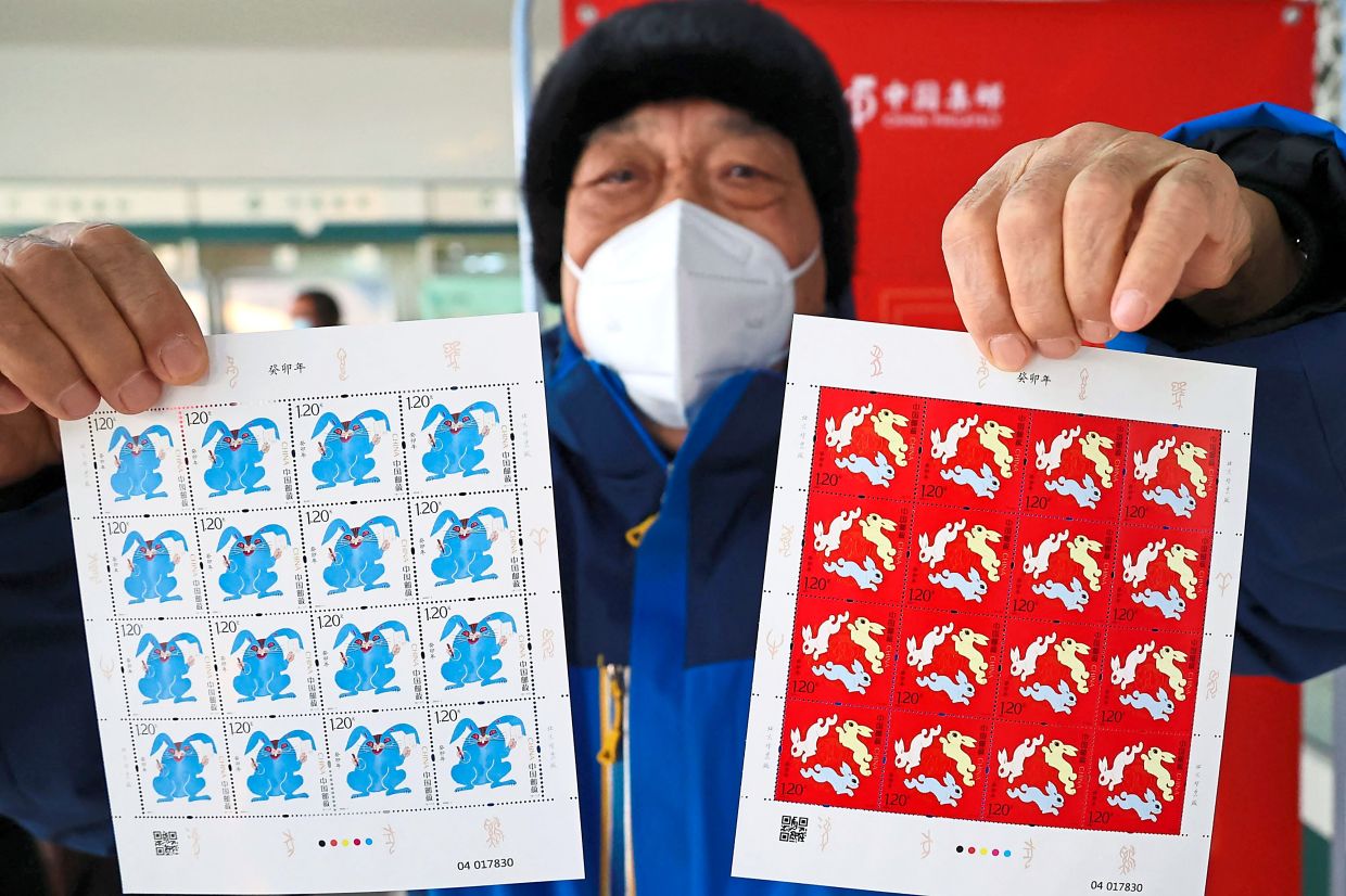 A man showing the Year of the Rabbit stamps at a post office in Lianyungang in China’s eastern Jiangsu province on Jan 5 ahead of the Lunar New Year. Photo: AFP