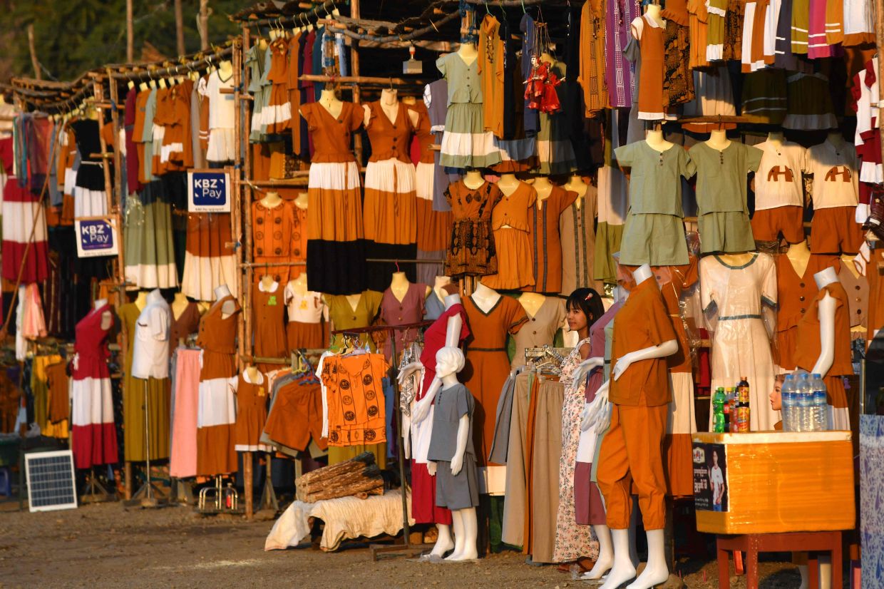 A vendor waiting for customers during the Mann Shwe Sat Thaw Pagoda Festival at Min Bu township in Magway Region. Devotees are returning in greater numbers to a central Myanmar temple, built around the gold-lined footprints of Buddha, after the Covid pandemic and a military coup curbed the annual pilgrimage. - AFP