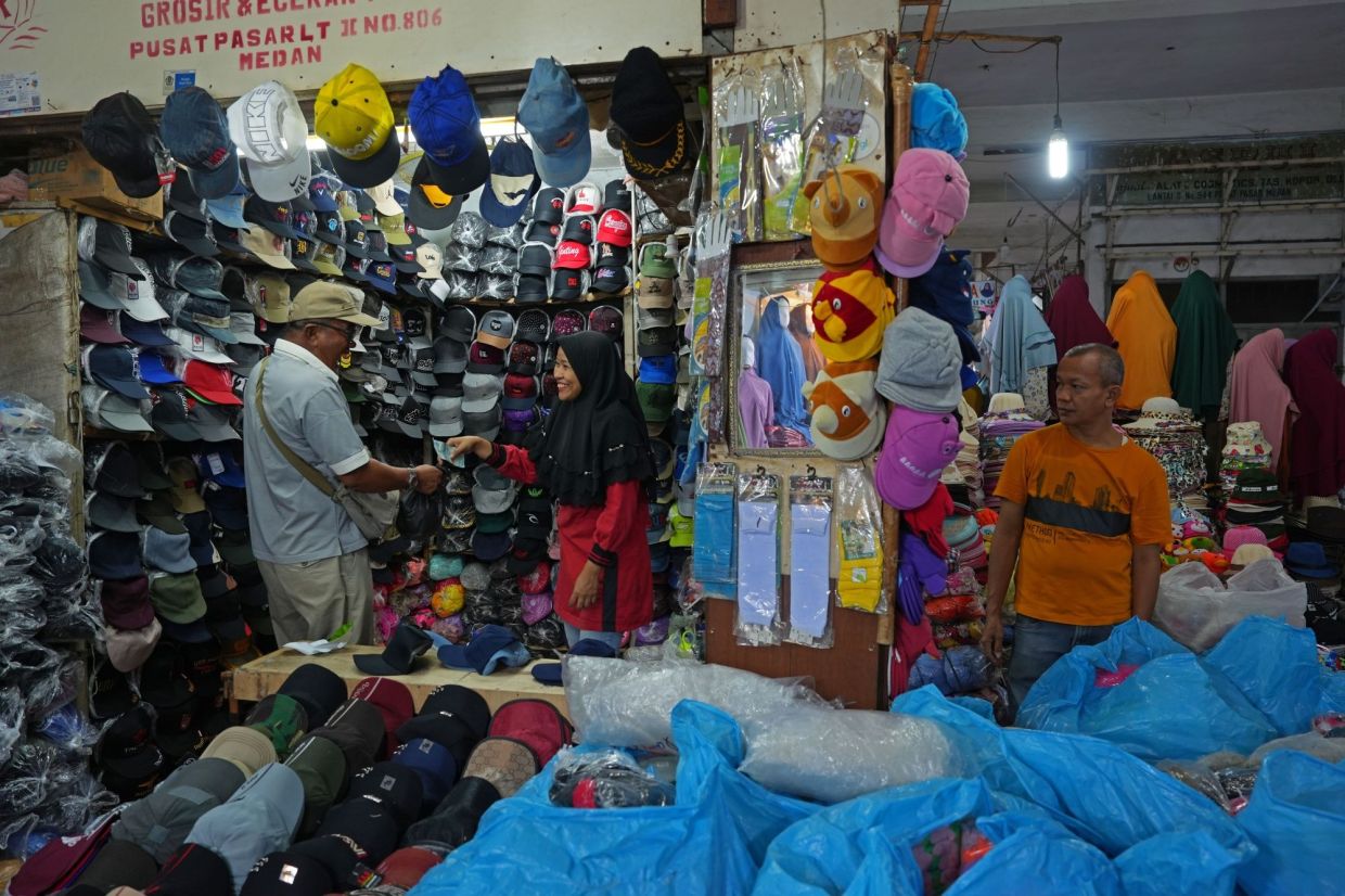 A shopper purchases a hat at a central market in Medan, Indonesia. Indonesia is scheduled to release the consumer price index (CPI) on Tuesday (Jan 31, 2023). - Bloomberg