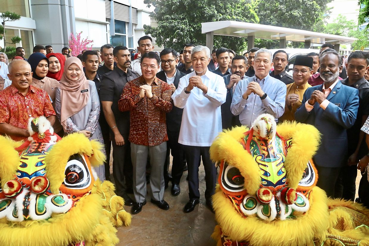 Best wishes: Flanking Ahmad Zahid (in white) are Nga and Fadillah, with other ministers and officials at the Local Govern­ment Development Ministry’s CNY celebration in Putrajaya. — FAIHAN GHANI/The Star