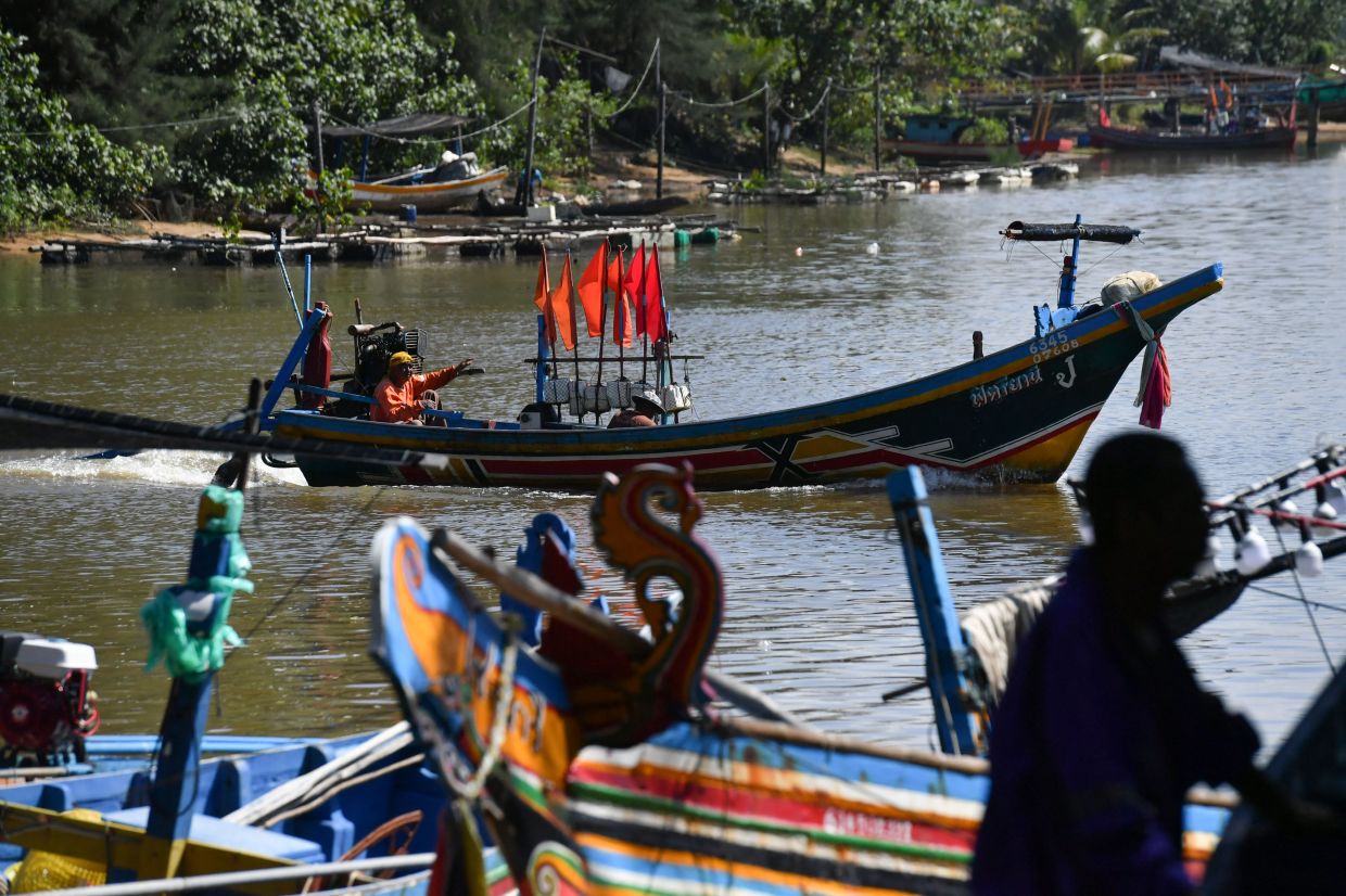 A fisherman navigates his boat on a waterway in Thailand's southern province of Narathiwat on February 7, 2023. - AFP