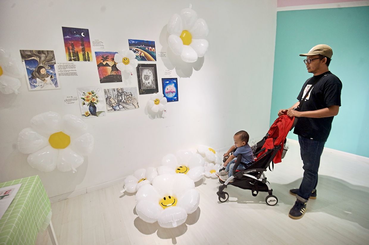 A visitor looking at artworks from children.