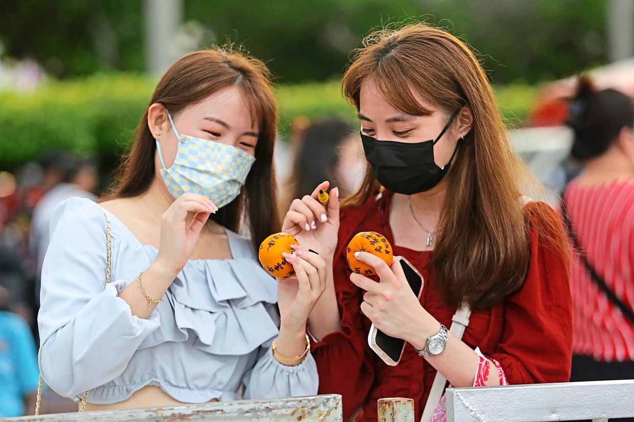 Two visitors preparing to take part in the orange-tossing ritual.