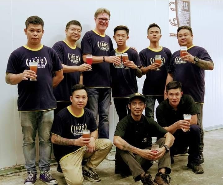 Liew (front, centre) and Gerner (back, centre) are the master craftsmen behind Sarawak's 1602 Craft Beer. 