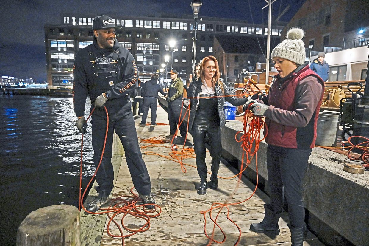 (From left) Woodard providing the line and magnet for Ali von Paris and Ally Mills to try magnet fishing at Broadway Pier. 