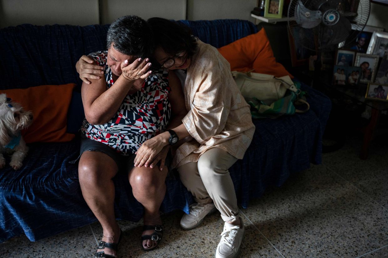 María Carolina Borges (D), miembro voluntaria de la asociación civil CONVITE, consuela a María Dolores Jaime (I) durante una visita a su apartamento para hablar sobre su estado general en el barrio de Petare, Caracas, el 30 de enero de 2023. – Foto: AFP