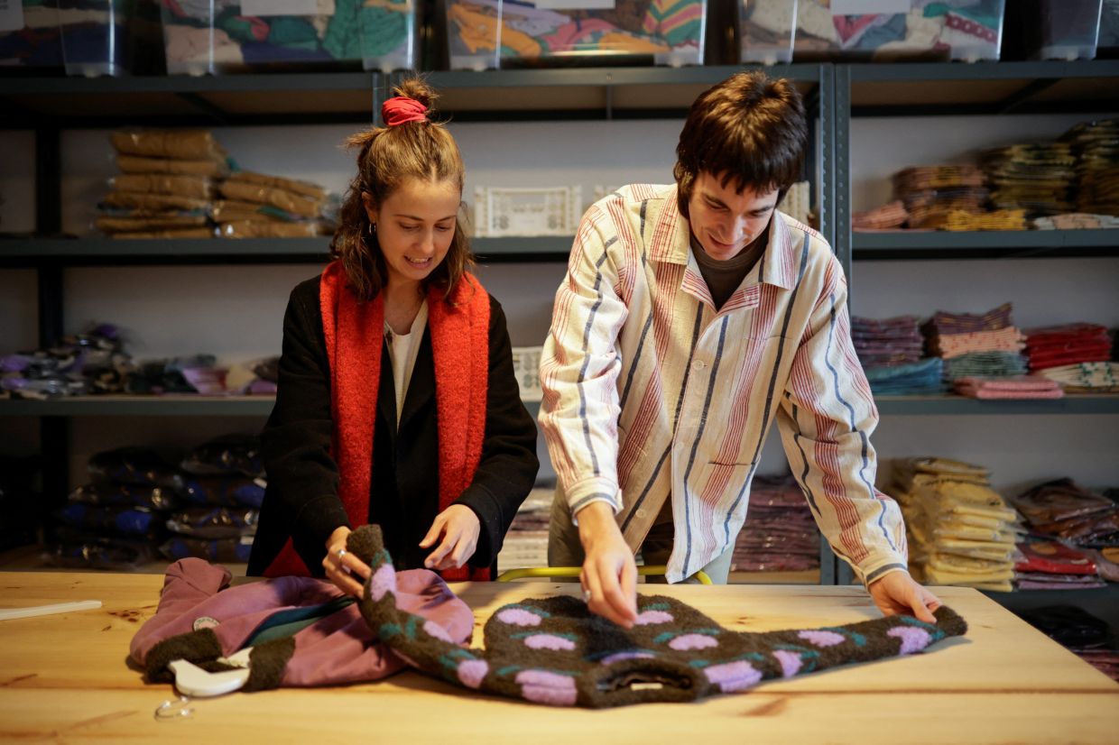 Jorge Toba and Antia Montero check items of their children's clothing brand The Campamento that produces two limited made-to-order collections per year and mostly with organic fibres. Photo: Reuters