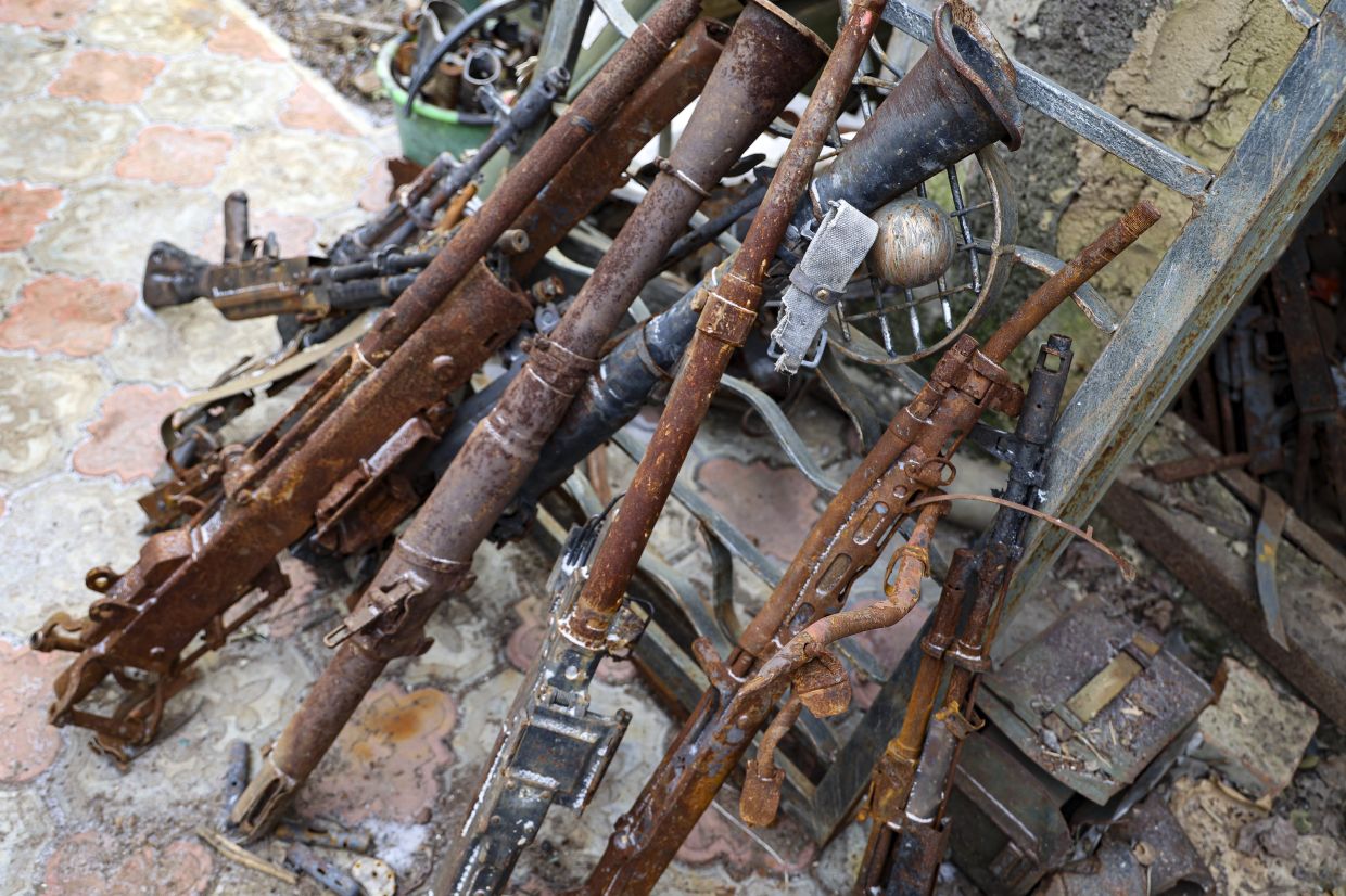 Old weapons and ammunition collected in a yard of a workshop in Mikhalev's house in Donetsk. Photo: AP