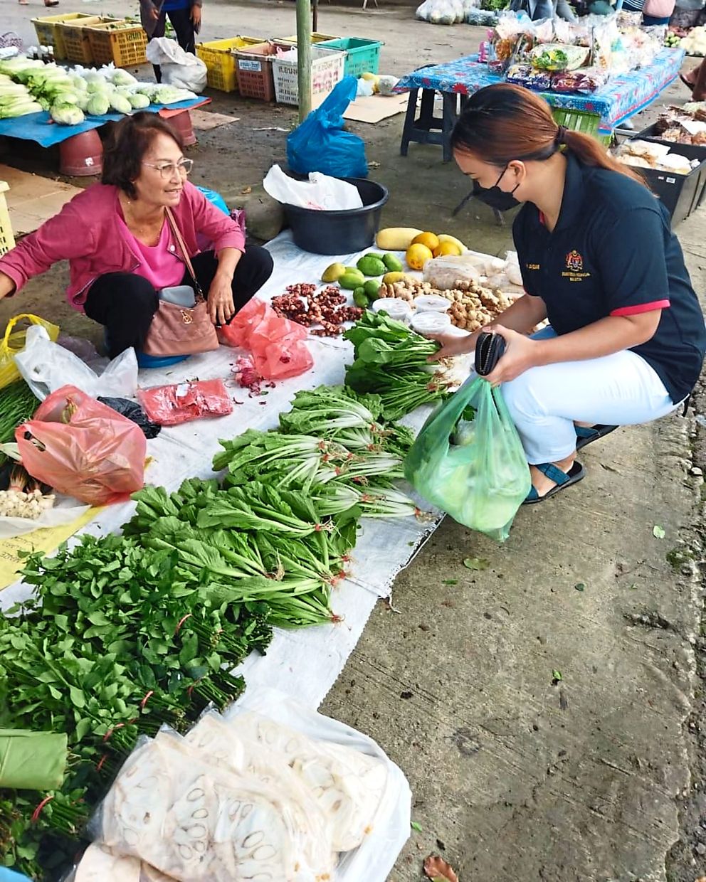 Kansimin (left) selling her abundant harvest at the town market.