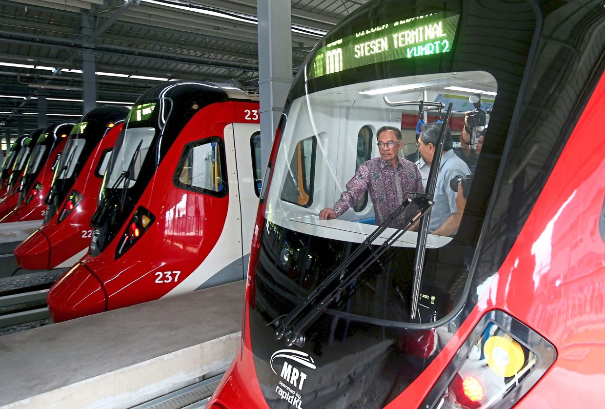 All aboard!: Anwar and MRT Corp CEO Datuk Mohd Zarif Hashim standing on board the new MRT train after the launch of the MRT Putrajaya Line at the Serdang MRT Depot. — AZHAR MAHFOF/The Star