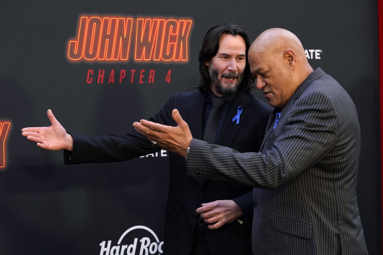 Keanu Reeves, left, and Laurence Fishburne, cast members in 'John Wick: Chapter 4', walk the carpet together at the premiere of the film on March 20, 2023, at the TCL Chinese Theatre in Los Angeles. Photo: AP