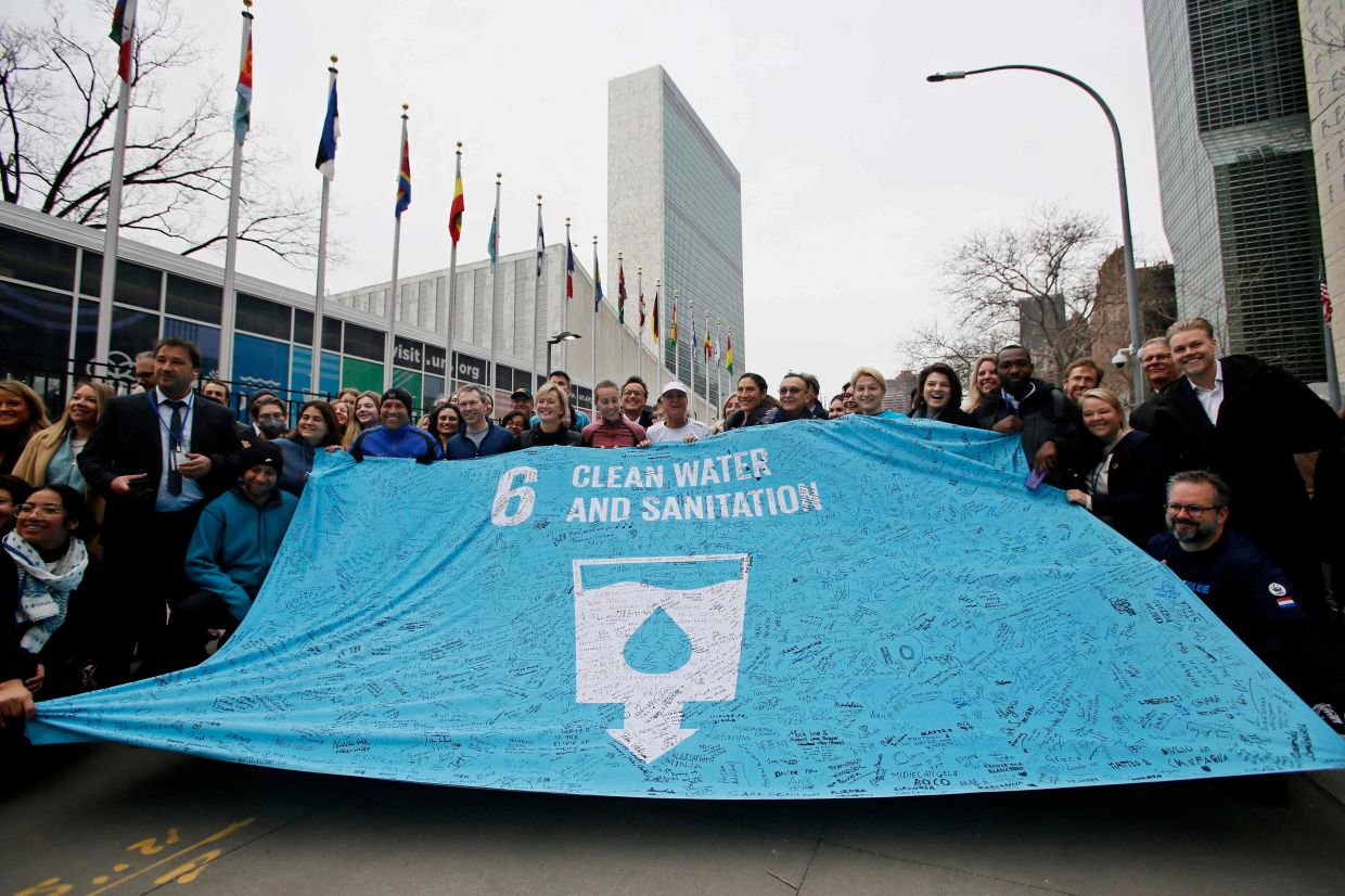 Guli (centre) holding a banner with supporters after completing her 200th marathon outside UN headquarters.