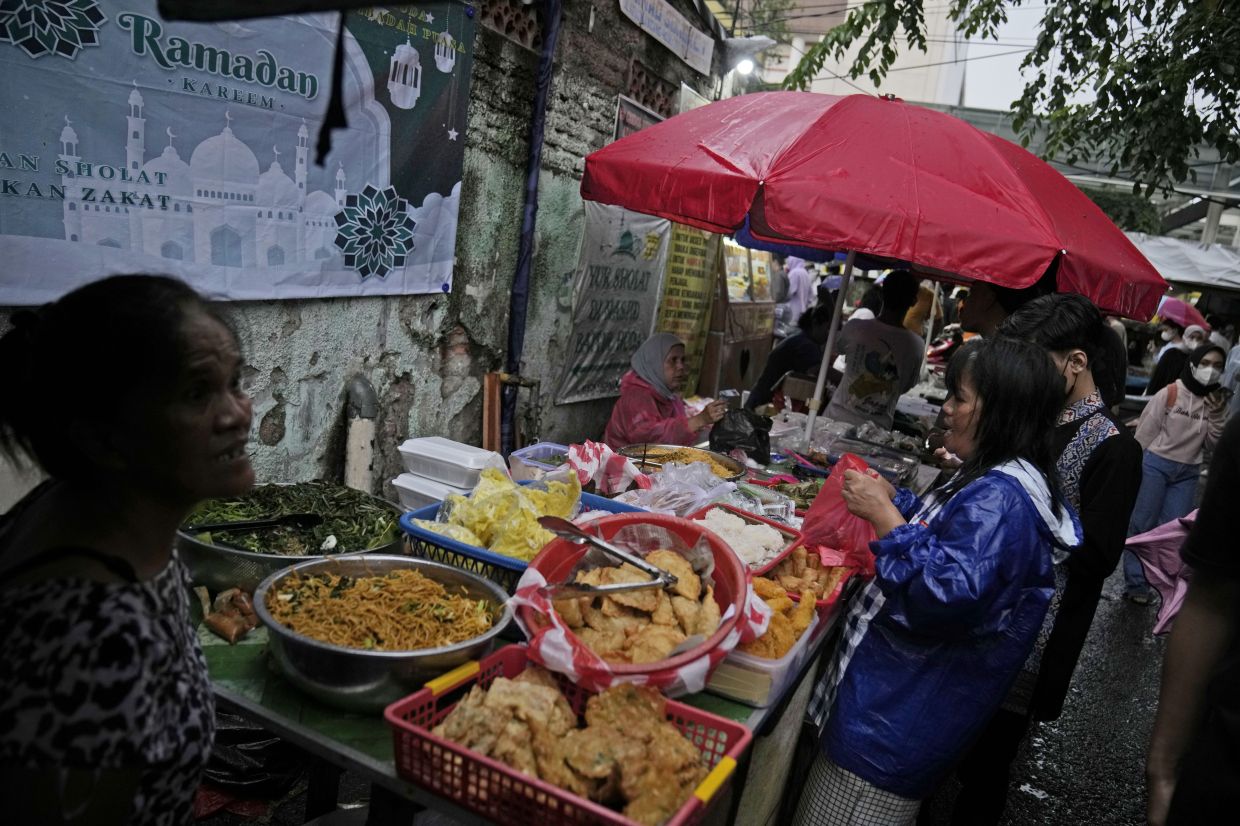 People by iftar food to break their fast during the first week of Ramadan in Jakarta, Indonesia, Saturday, March 25, 2023. Muslims around the world are observing Ramadan, the holiest month in Islamic calendar, where they refrain from eating, drinking, smoking, and sex from dawn to dusk. - AP