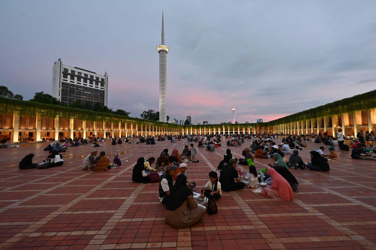 Muslims break their fast on the fourth day of the holy Ramadan at the Istiqlal mosque on Sunday, March 26, 2023. - AFP