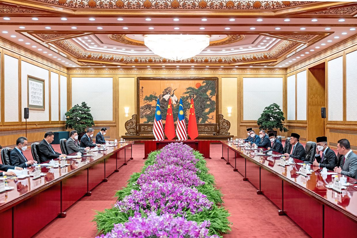 Honoured: Anwar (second from right) and Xi (second from left) exchanging views at the Great Hall of the People in Beijing. — Prime Minister’s Office