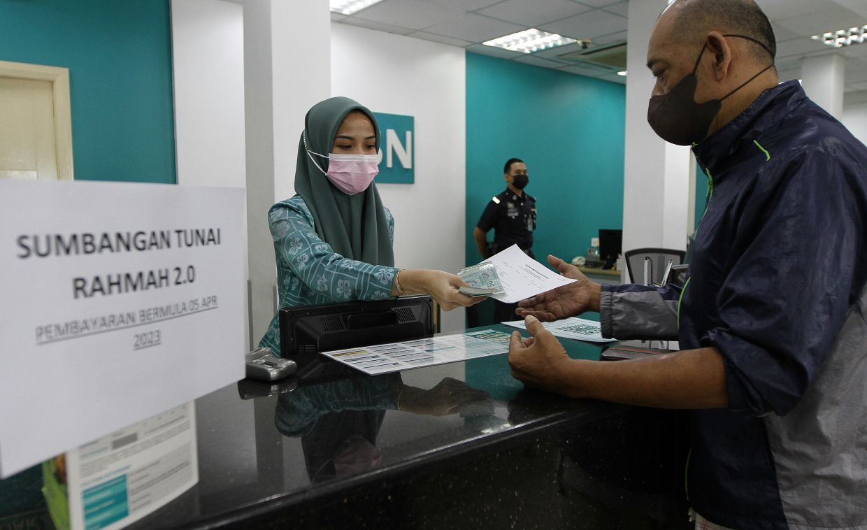 A Sumbangan Tunai Rahmah beneficiary getting his cash aid at the Bank Simpanan Nasional branch in Bukit Mertajam.