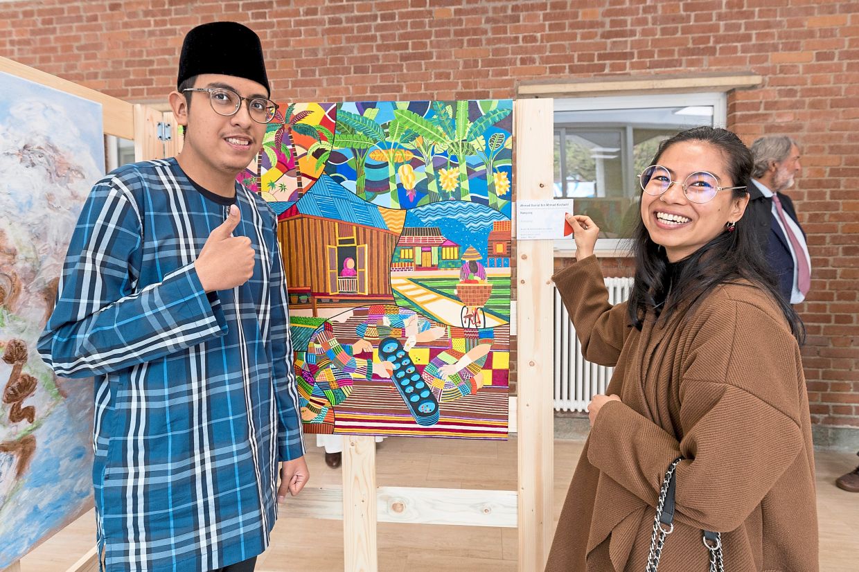 Danial (left) with Silwin Aw, who together with Luca Pignatti, took home the colourful and nostalgic 'Kampung' painting. Photo: Bonnie Yap 