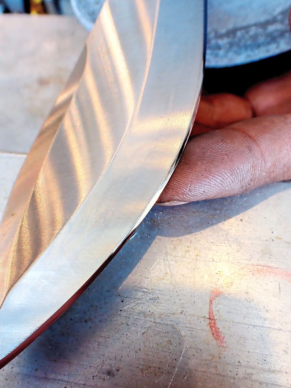 After a 10-minute treatment on Mohd Faddli’s belt sharpener, the chipped edge is ground away and a mirror finish is added to the edge.