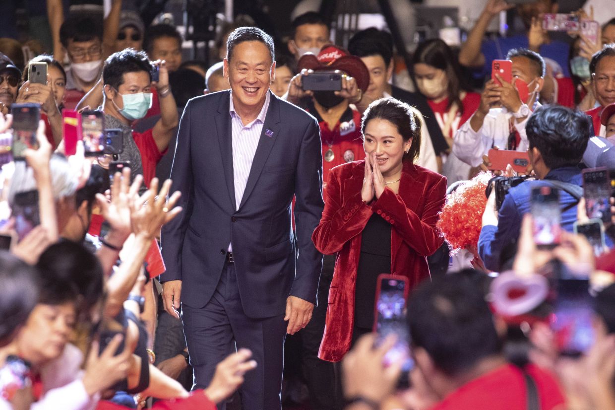 Pheu Thai Party’s prime ministerial candidates Paetongtarn Shinawatra (right), and Srettha Thavisin greet supporters at the party’s final campaign event in Bangkok, Friday, May 12, 2023, ahead of Thailand’s May 14 general election. - AFP