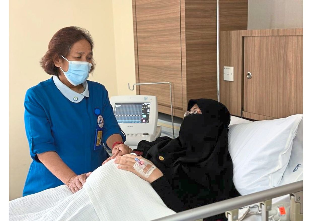 Jamilah comforts a patient before she is due to deliver her child. Jamilah’s current job allows her to finally practise her midwifery skills after an entire career of not being posted to the labour room! — JAMILAH SHAMSUDDIN