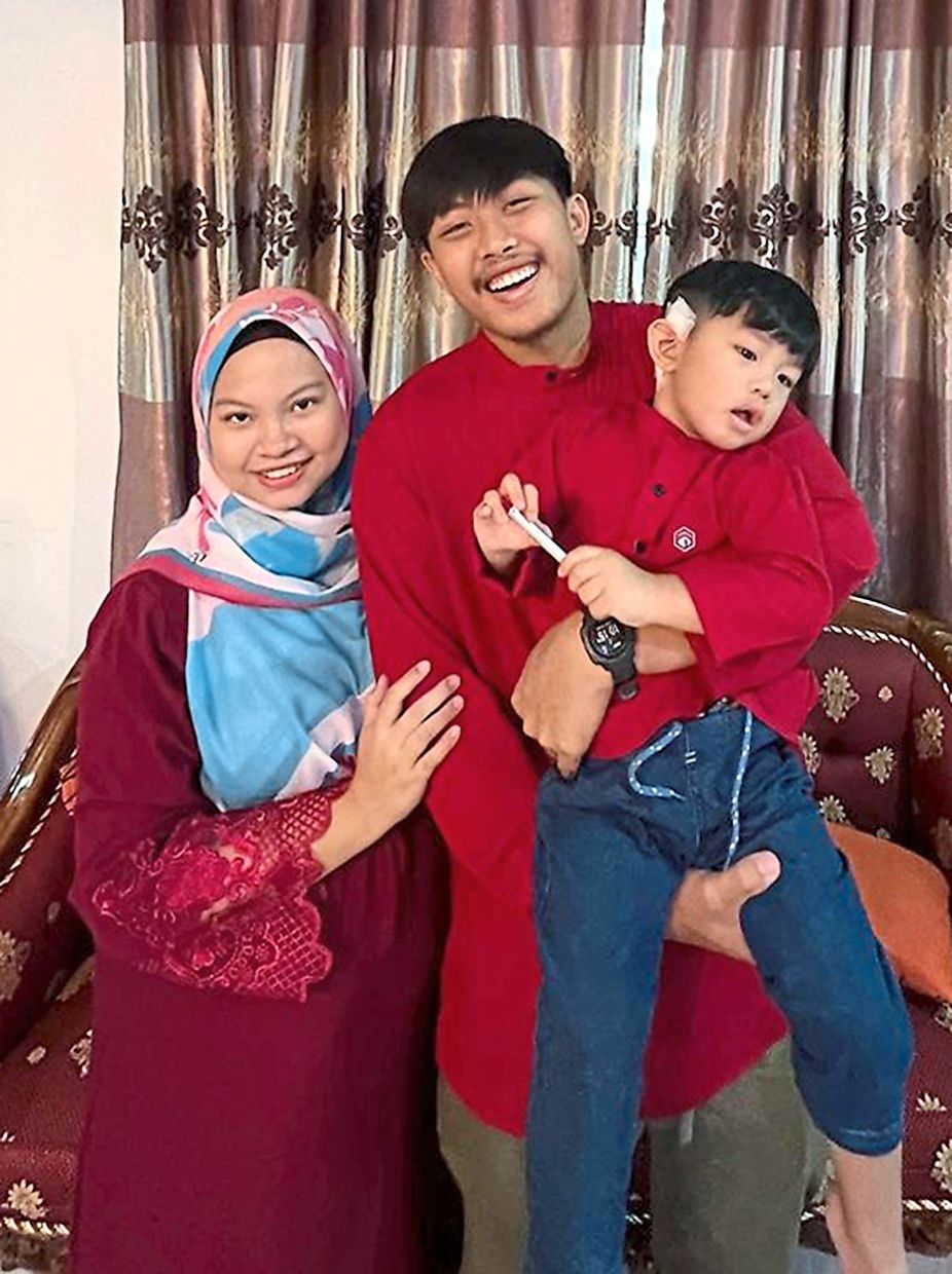 Adhwa with mother Nurul Atiqah and father Muhammad Hazim Shah during the recent Hari Raya Aidilfitri festivities after the cochlear implantation.