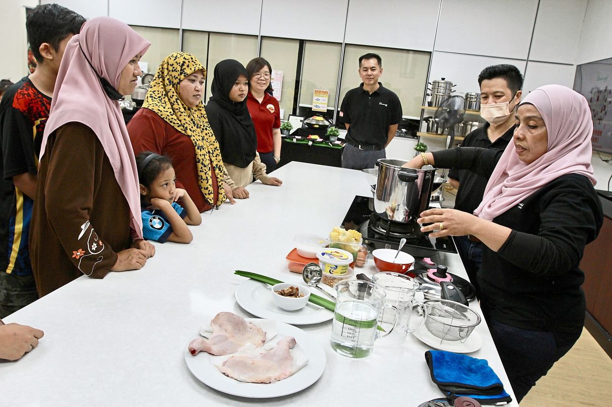 Tourists getting to try out the stainless steel cookware during a cooking demonstration.