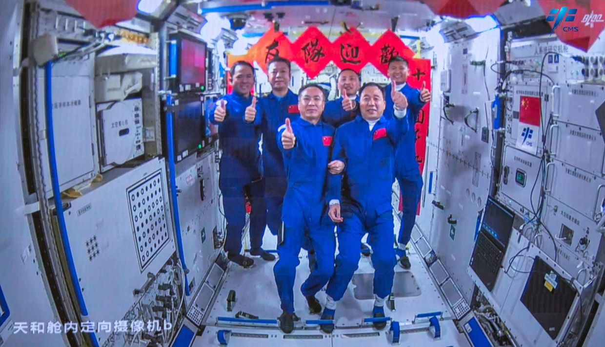 Crew of the Shenzhou-15 spaceflight mission Fei Junlong (front Left), Zhang Lu (back Left) and Deng Qingming (back second left) take photos with crew of the Shenzhou-16 spaceflight mission Jing Haipeng (front R), Gui Haichao (back R) and Zhu Yangzhu (back 2nd R) inside the Chinese space station core module Tianhe on May 30, 2023. China sent three astronauts to its Tiangong space station on May 30, putting a civilian into orbit for the first time as it pursues plans to send a crewed mission to the Moon by 2030. - AFP