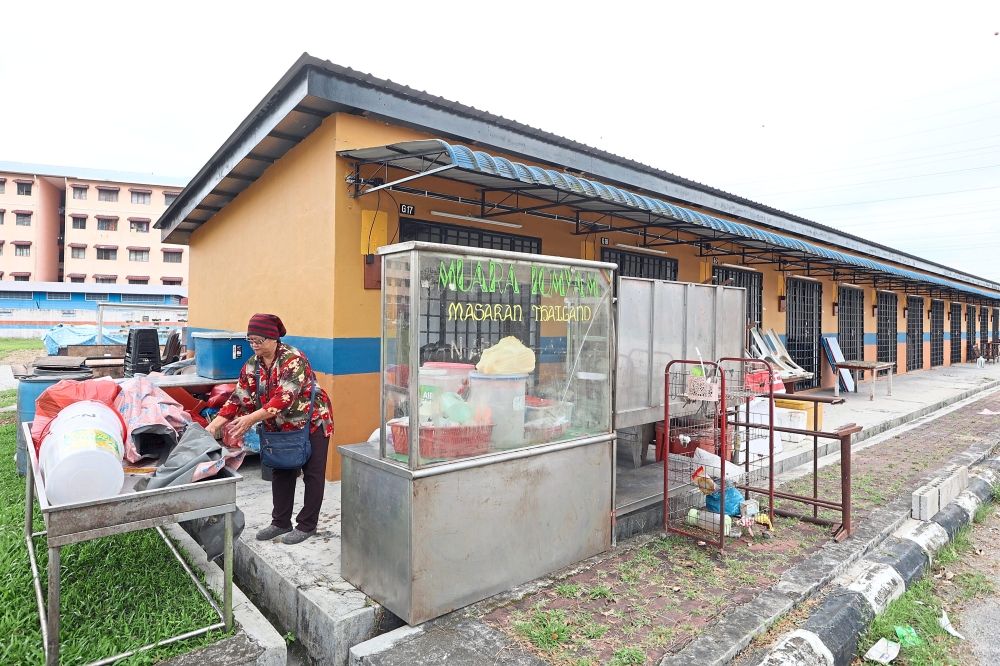 Space constraints: Maimunah Othman, 57, setting up her stall after relocating to Gerai PPR Desa Mutiara. — Photos: THOMAS YONG/The Star