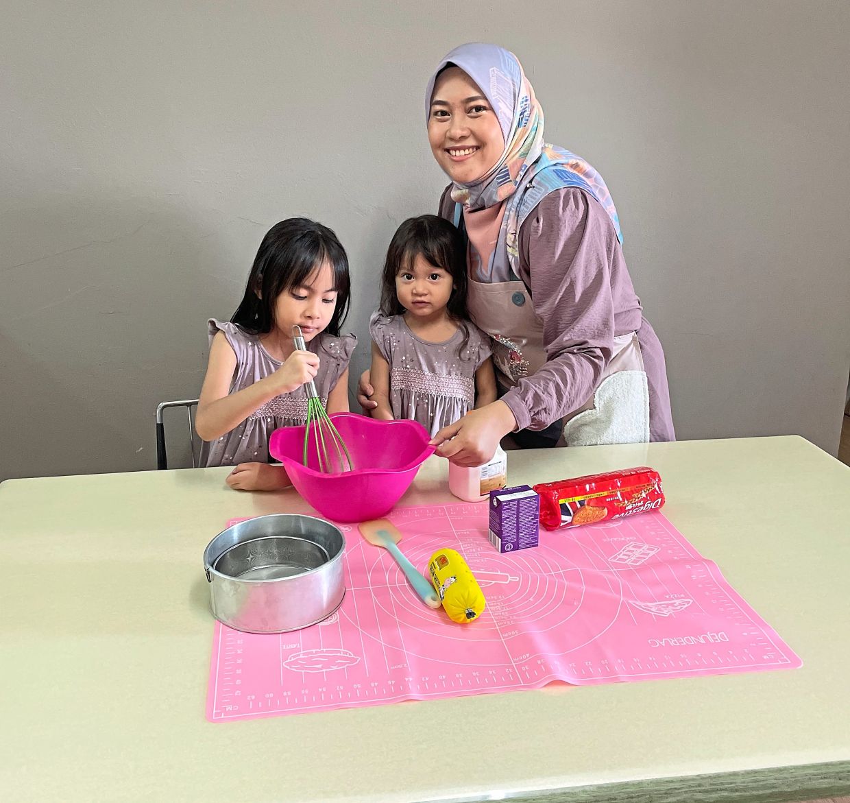 Nur Hazirah says baking with her daughters Audrey Nadia Ihsan (left) and Audrey Diana Ihsan enables her to bond with them.