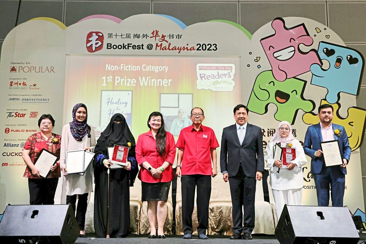 Literary recognition: Chor (fourth from right), Wee (third from right) and Ng (fourth from left) with the award winners at the prize-giving ceremony at Bookfest@Malaysia 2023, Kuala Lumpur Convention Centre.                              — AZMAN GHANI/The Star