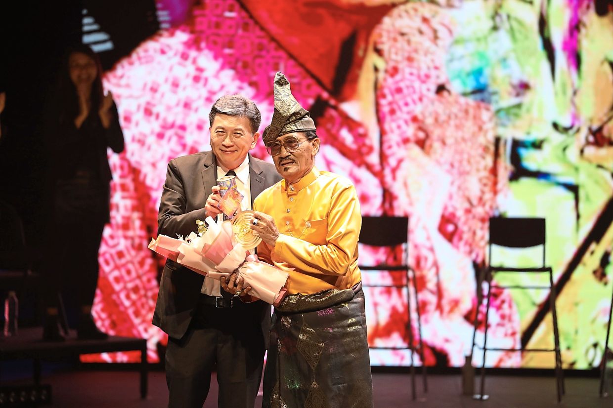 Mohd Baharim (right), a veteran dondang sayang champion from Melaka, receiving the the Lifetime Achievement Award from Boh Plantations CEO Jason Foo at PJPAC on May 14. Photo: Kakiseni