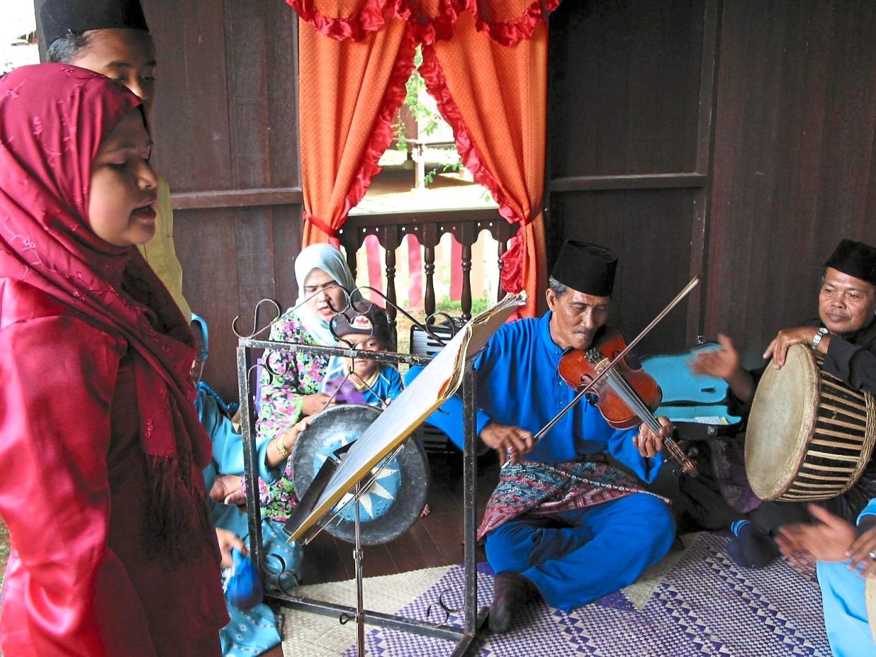 Mohd Baharim (in blue) leading a dondang sayang performance in a traditional house in Taman Mini Malaysia in Melaka in 2011. Photo: Filepic/The Star 