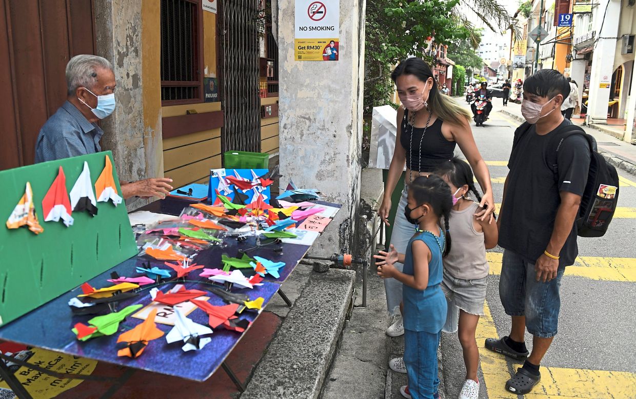 Ee selling his craftwork at the Armenian Street weekend market.