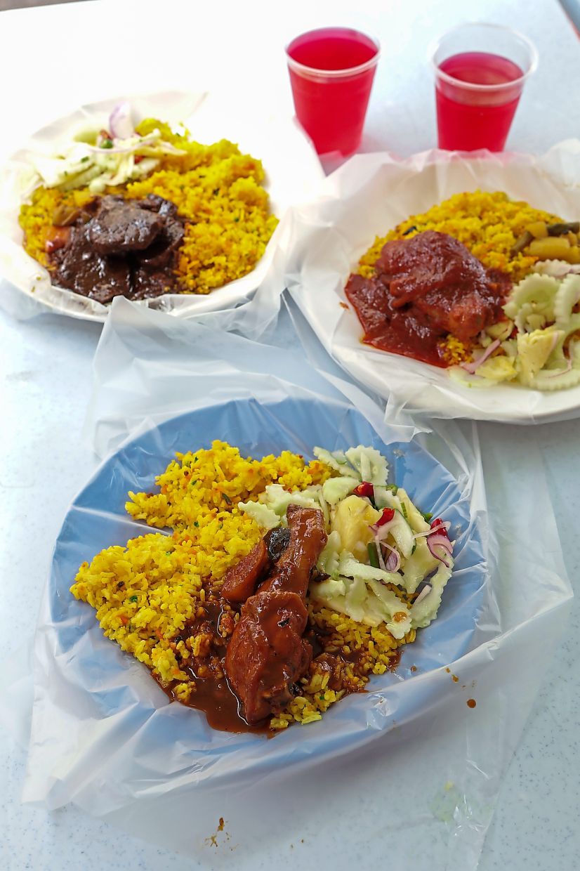 Nasi hujan panas served with (clockwise from left) daging hitam, ayam rose, ayam madu and acar.