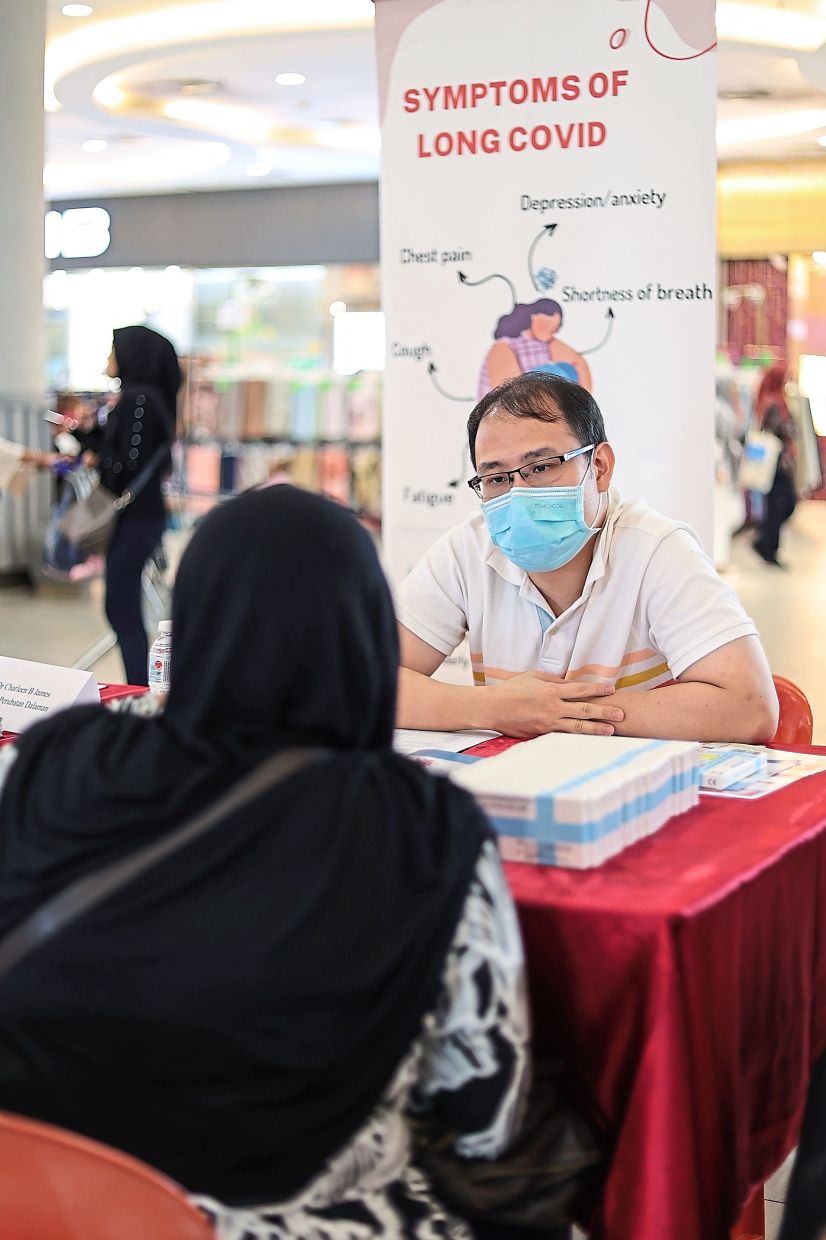 A visitor consulting with internal medicine specialist Dr Loo Wei Hoong about long Covid at the event.