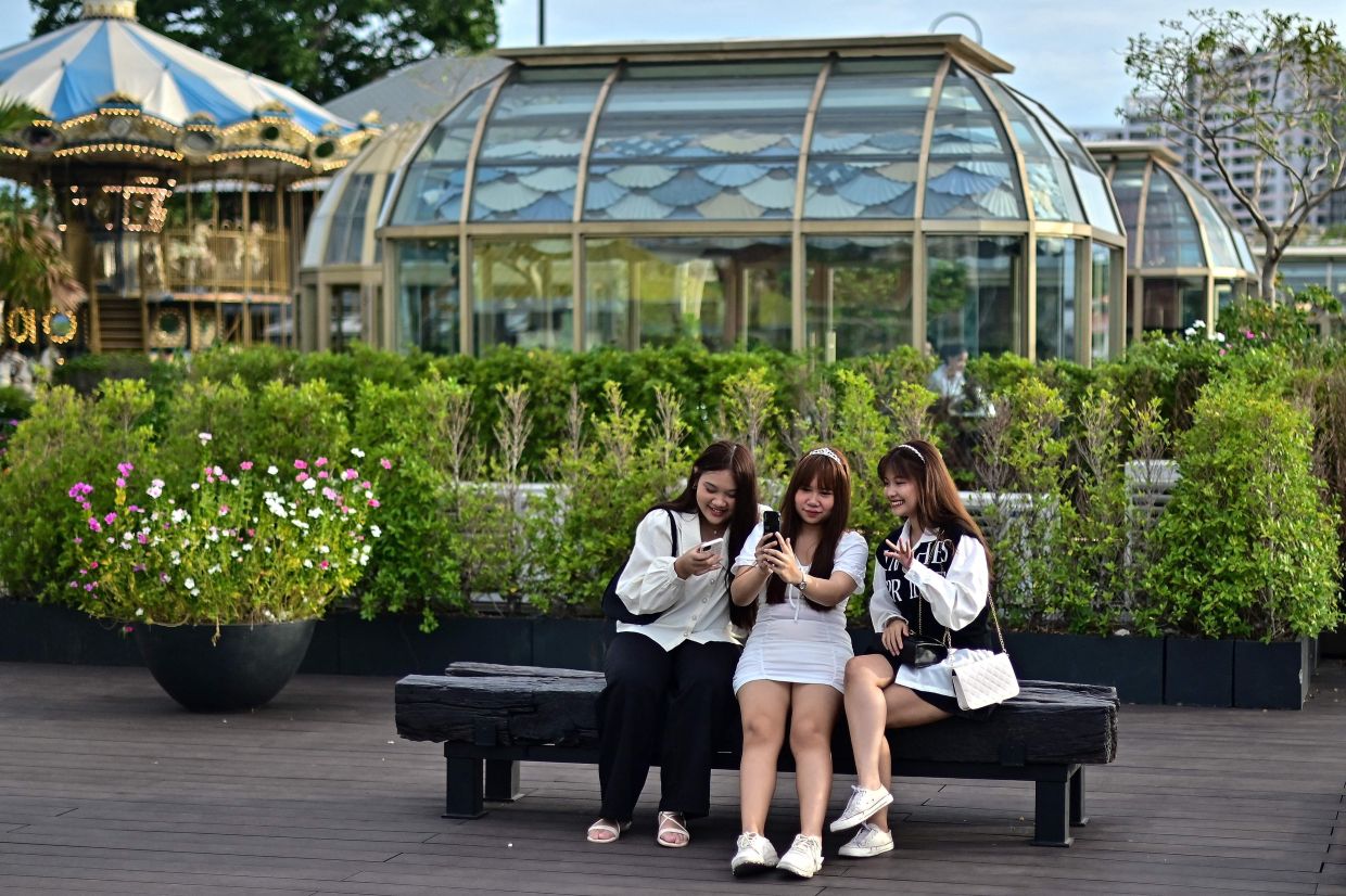 Women pose for a selfie at the Asiatique Riverfront along the Chao Phraya river in Bangkok on Saturday, June 11, 2023. - AFP