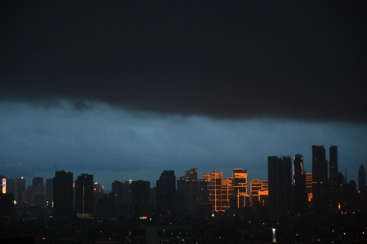 Dark clouds are seen over the skyline of the financial district of Makati in suburban Manila on Sunday, June 11, 2023. - AFP