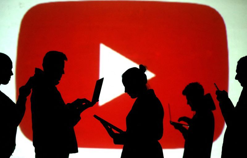 FILE PHOTO Silhouettes of laptop and mobile device users are seen next to a screen projection of the YouTube logo in this picture illustration taken March 28 2018.  REUTERSDado Ruvic