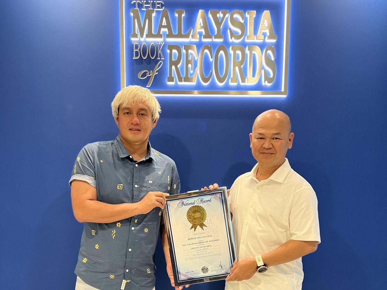 （左）Roihan 从 Ahmad Zaki 手中接过证书。