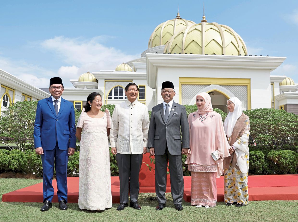 Cordial friendships: The King (third from right) and the Queen (second from right) sharing a relaxed moment with Marcos Jr and Araneta-Marcos (third and second from left respectively). They are flanked by Anwar and Wan Azizah.
