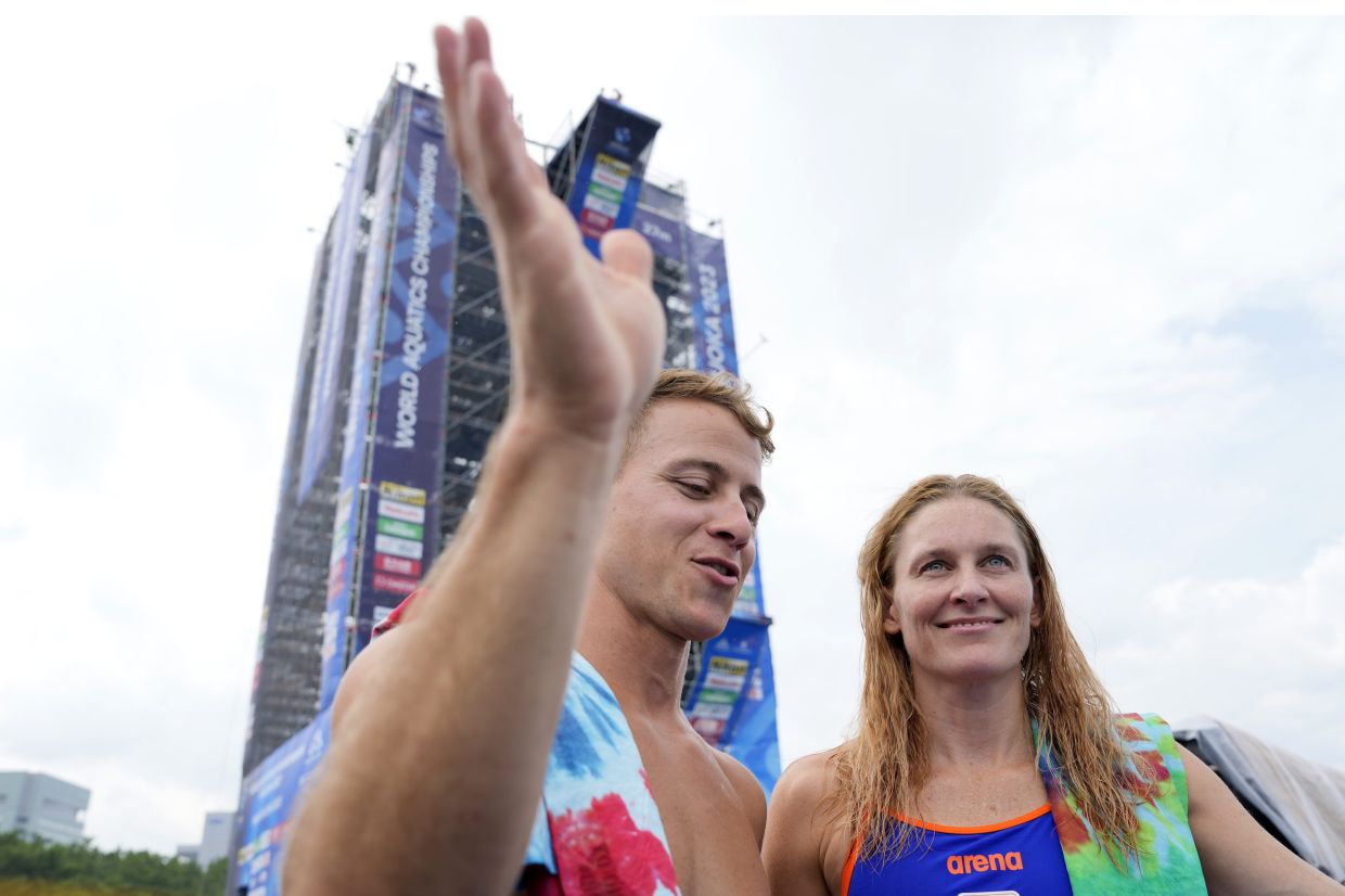 Power couple: Matt Cooper (left) and his wife Ginni van Katwijk speaking after a practice session in Fukuoka.-AP
