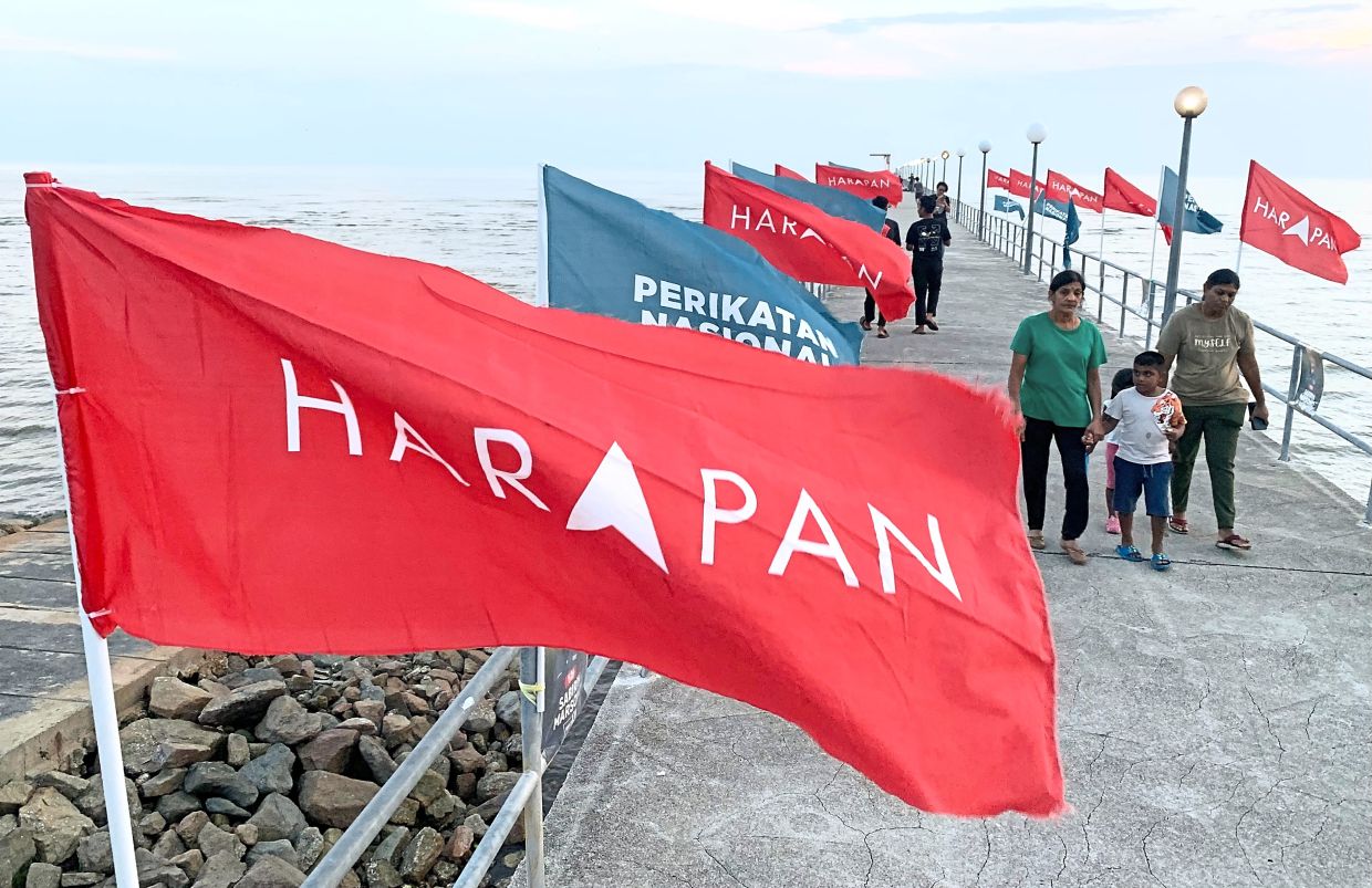 High hopes: Visitors walking past political banners in Tanjong Sepat, Kuala Langat, Selangor. – SS KANESAN/The Star