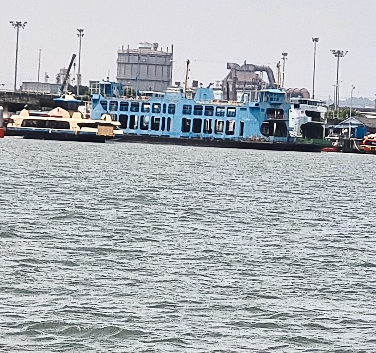 The big and small of it: The new ferry looks tiny as it leaves the berth, with two of the old iconic ferries parked nearby.