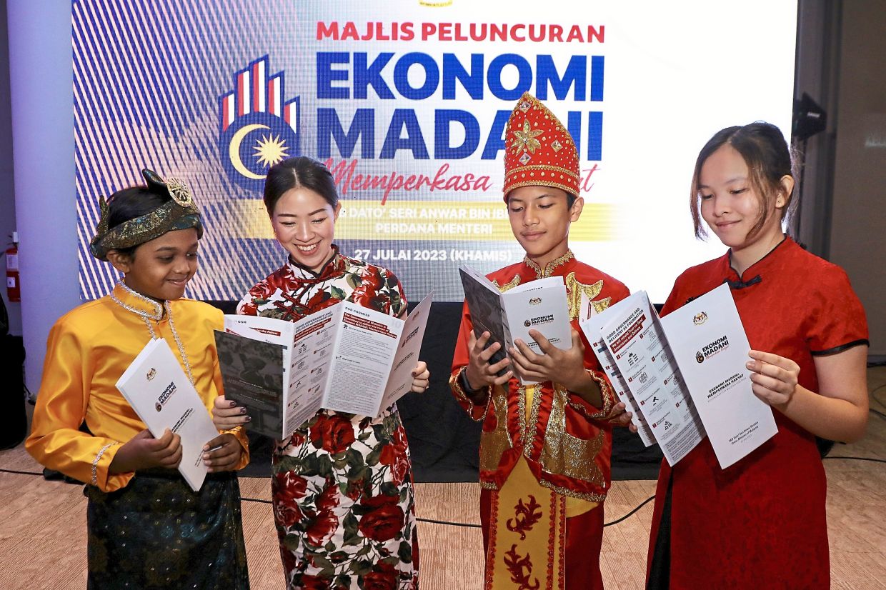 Guests (from left) Elijah Jayden Seevaratnam, Amelia Lau, Mohamed Eijaz Ahmad Faezal and Brendy Yap looking at the information booklet on Ekonomi Madani at its launch in Kuala Lumpur recently.