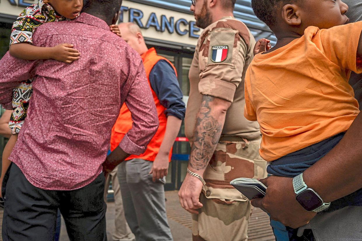 A photo showing a French soldier assisting with evacuations this week in Niamey, Niger.  — ©️2023 The New York Times Company