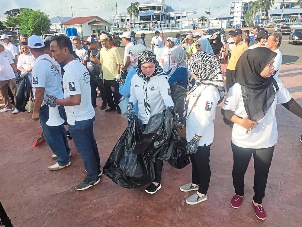 Collective effort: Volunteers cleaning up Semporna town during a gotong royong organised by Parti Warisan.